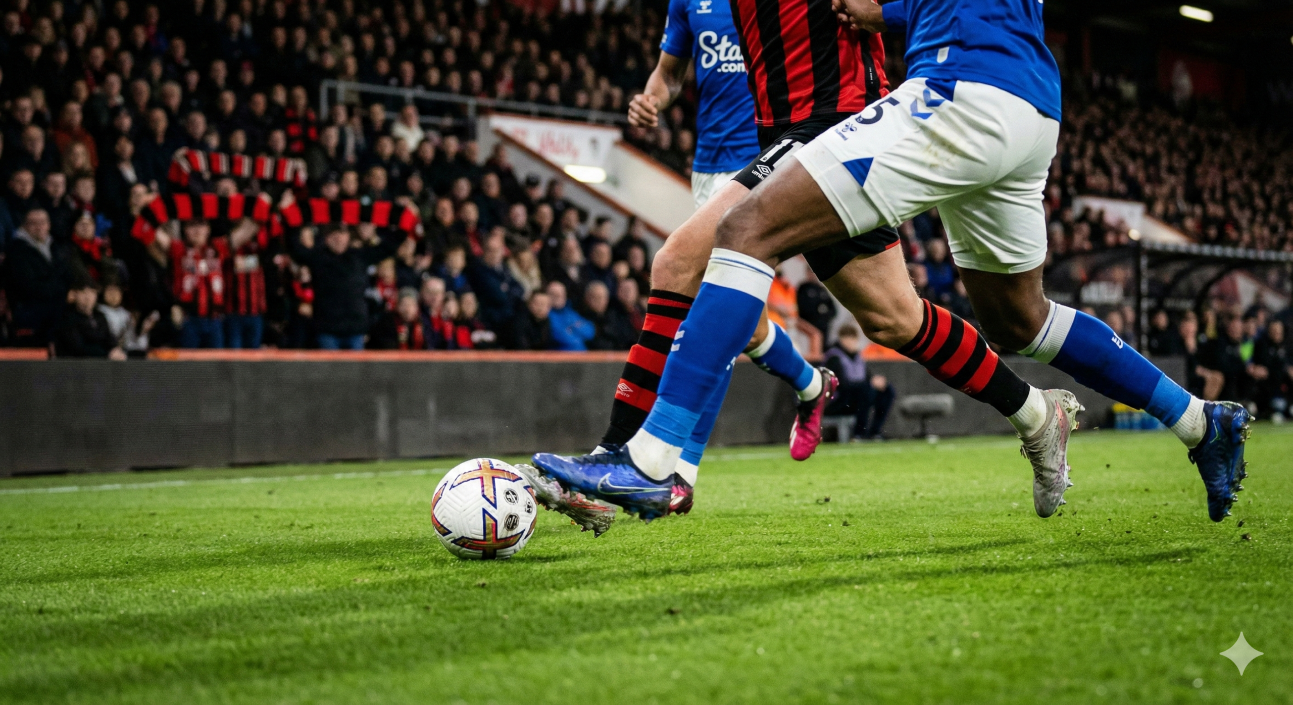 An immersive action shot focused on the pitch level at Bournemouth's home ground, capturing the determination of 'The Cherries' to return to winning ways. The image focuses on the lower body of players in motion, highlighting the red and black socks of Bournemouth and the blue of Everton, with a football in sharp focus on the green turf. The background features a depth-of-field effect blurring the stadium stands filled with expectant fans. The lighting is dramatic, simulating a professional night match environment. The visual style is crisp, high-definition sports journalism photography intended to break up the text and add visual interest to the match analysis.